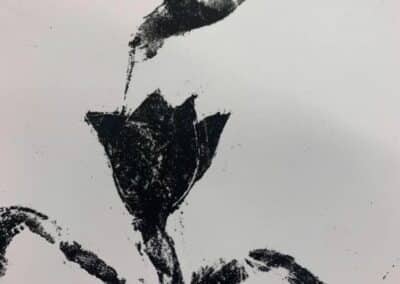 Black and white lithograph print of a hummingbird taking nectar from a flower