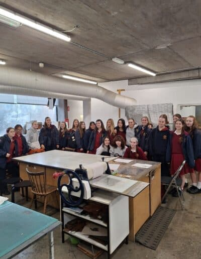 Large group of school pupils standing in etching workshop