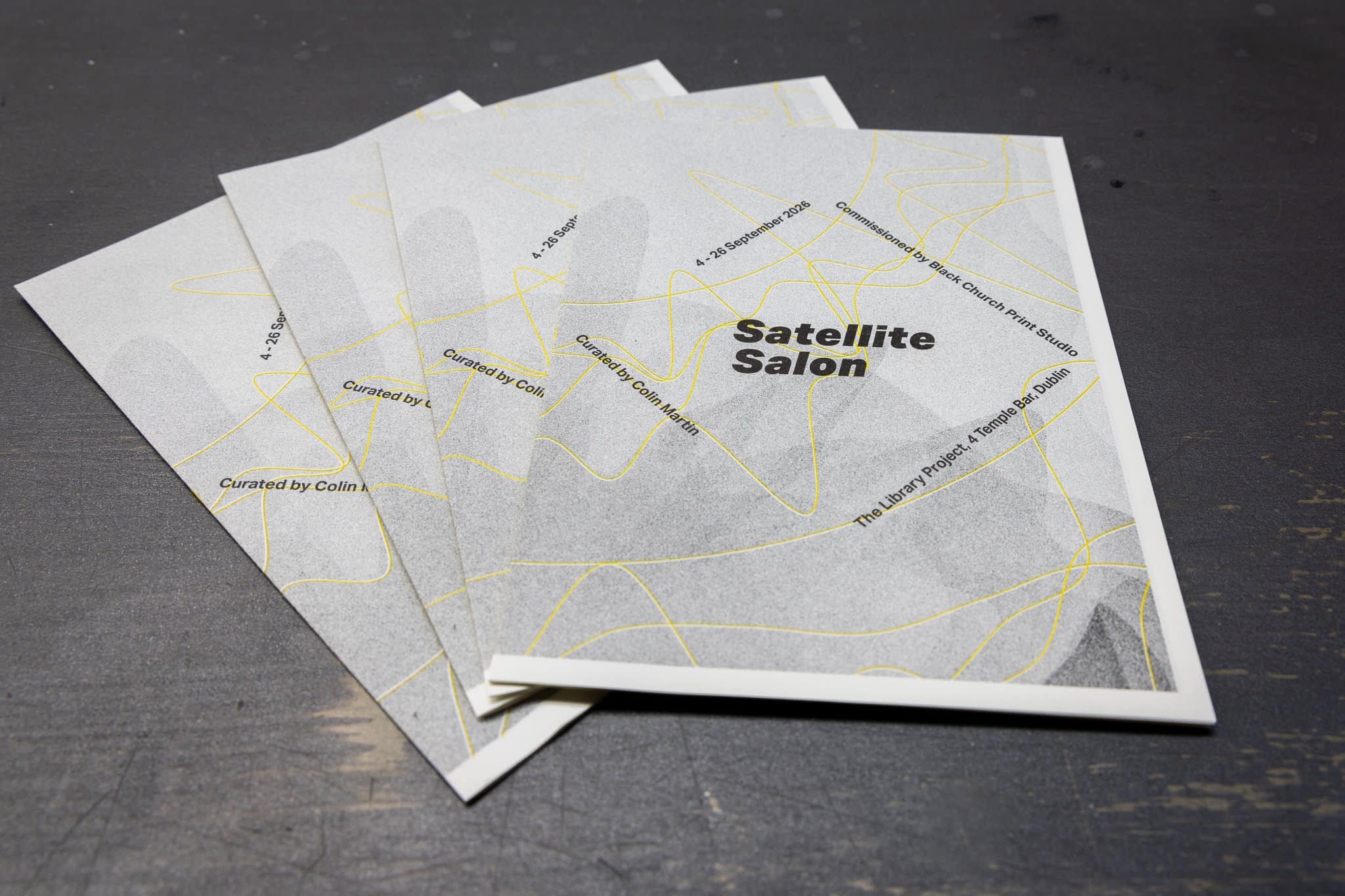 Four black and white booklets fanned out on top of each other.